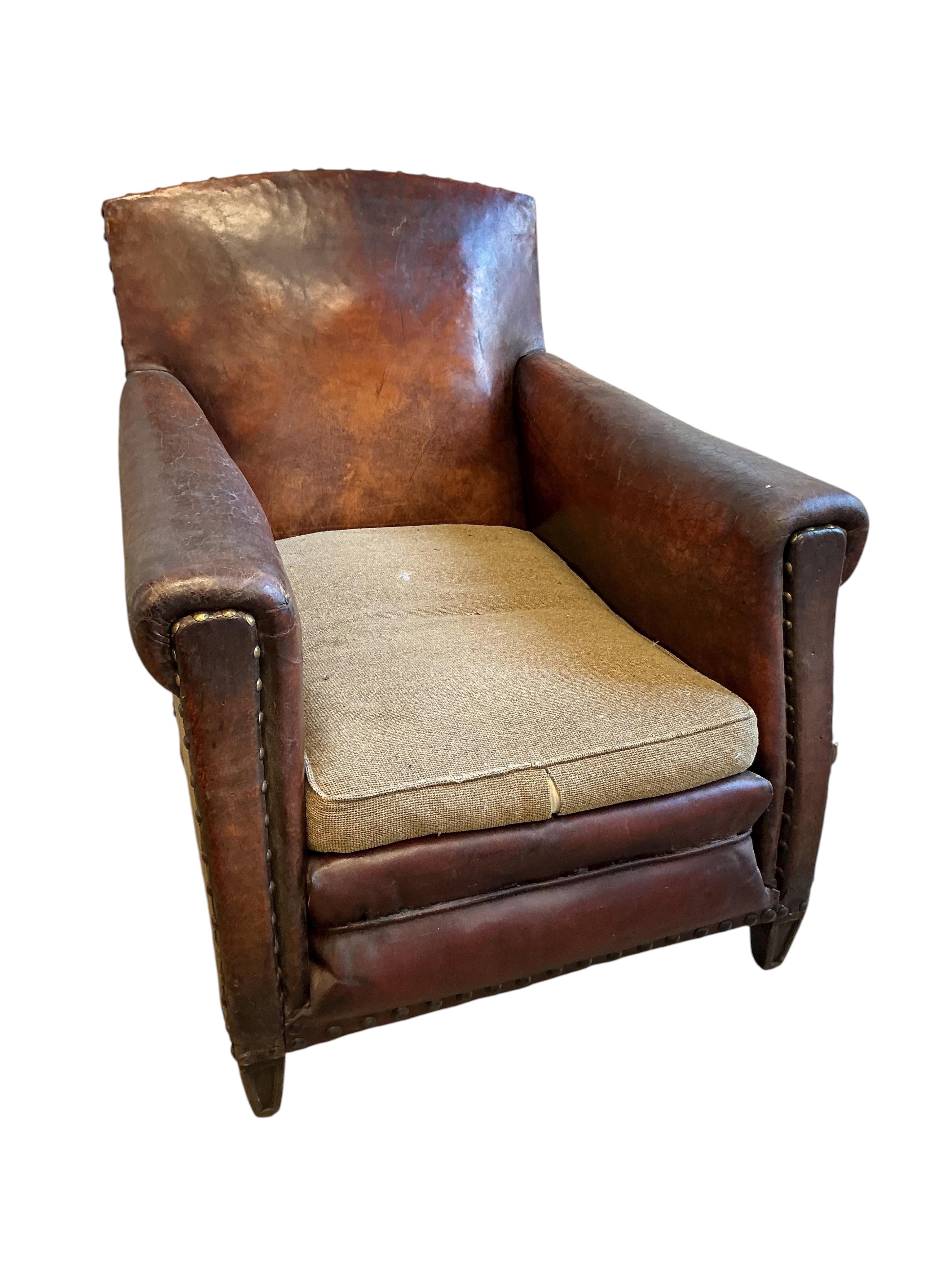A near pair of early 20th century studded brown leather club chairs, width 79cm, depth 86cm, height 89cm